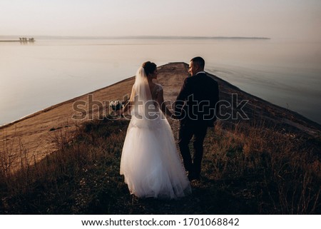 Bride and groom, newlyweds, honeymoon on the seashore sunset sun