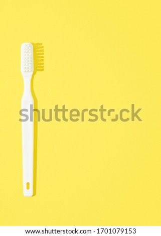 Toothbrush on yellow pastel background. 