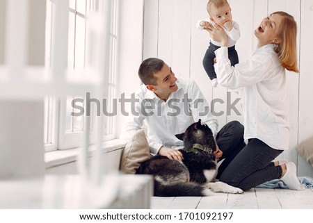 Cute family in a room. Lady in a white shirt. Family sitting with big dog.