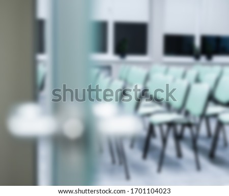glass door in an open office room in a business center against a white wall. Business space with a glass door and a metal handle. Blurred image as background for business