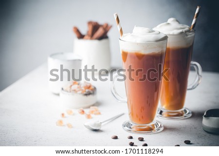 Iced coffee in a tall glasses with cream poured over