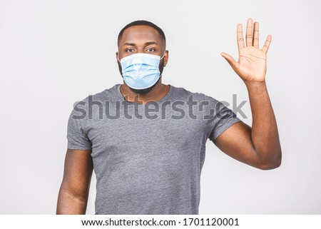 African american man with mask to protect him from Coronavirus. Corona virus pandemic. Stop sign. Person in medical mask. Isolated over white background. Covid-19.