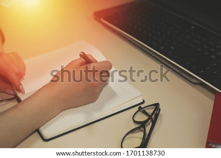 Modern beige office desk with laptop, smartphone and other expenses with a cup of coffee. Blank notebook page for entering text in the middle