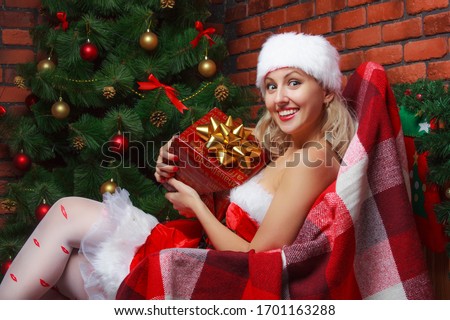 Girl with gift in hand in new year's interior with smile