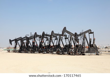 Black oil pump jacks in the desert of Bahrain
