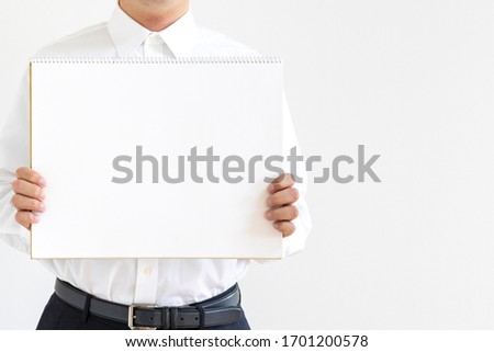 Man in business shirt holding blank sketchbook