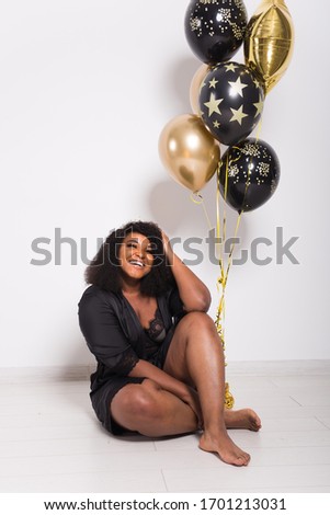Holidays, birthday party and fun concept - Portrait of smiling young African-American young woman looking stylish on white background holding balloons.
