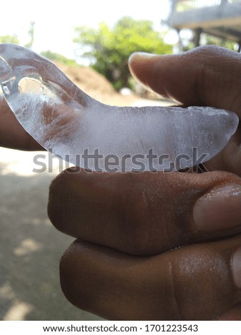 A small unique ice piece in the hand of person