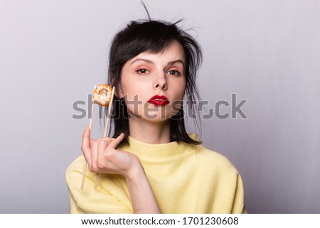 Woman with food in her hands. Sushi on sticks