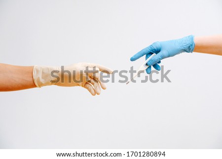 close-up hands of people in protective gloves pass a Digital Thermometer 