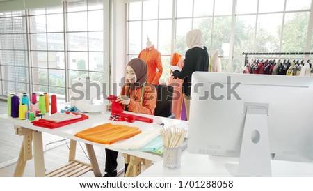 2 Asian Muslim female designers designing clothes Is in the office very often
