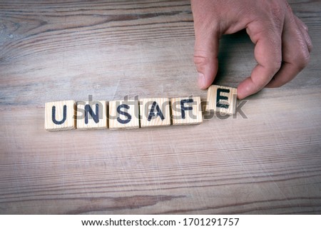 UNSAFE. Security measures, law and regulations concept. Alphabet letters on wooden table