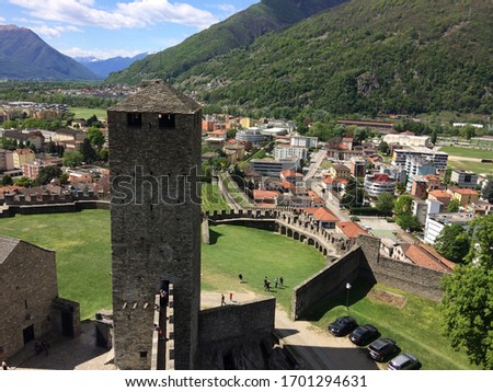 
View of the tower of the medieval castle on the city of Bellinzona, UNESCO heritage, mountains, woods, city walls, Bellinzona Switzerland