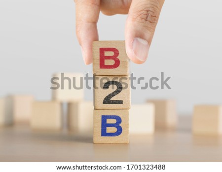 Hand arranging wooden blocks with the word B2B. Business to business marketing concept.