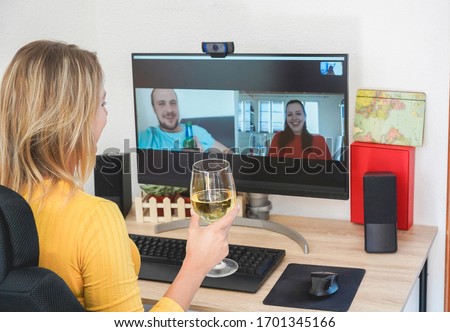 Young woman chatting with friends drinking wine and laughing together - Alternative party during home isolation quarantine - Focus on glass hand Royalty-Free Stock Photo #1701345166