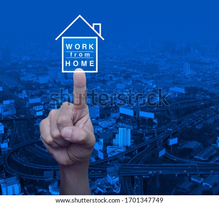 Hand pressing work from home flat icon over modern city tower, street, expressway and skyscraper, Business social distancing concept