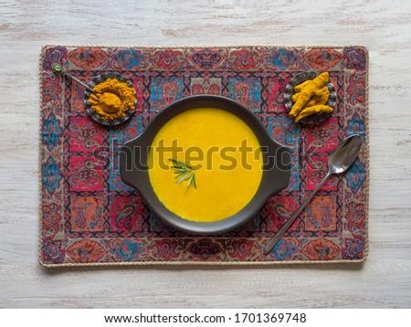 Healthy curcuma cream soup on white wooden background. Prevention of antiviral infections. Spices for ayurvedic treatment. Alternative medicine concept. Royalty-Free Stock Photo #1701369748