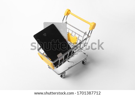 credit cards in shopping cart isolated on a white background. Purchasing power and living wage concept.