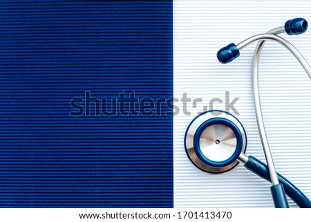 Blue stethoscope close-up on a white background on the right, empty dark blue background for recordings on the left