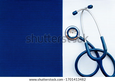 Blue stethoscope on a white background on the right, empty dark blue background for recordings on the left