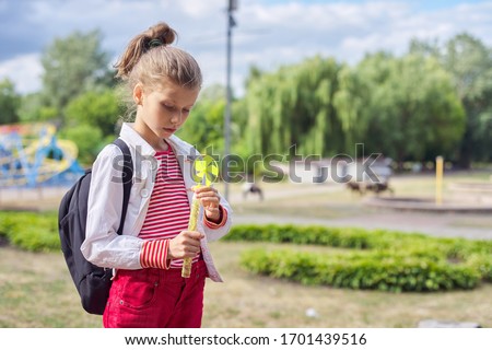 Outdoor portrait of 9, 10 year old blonde child gir, park, sky in clouds background, copy space