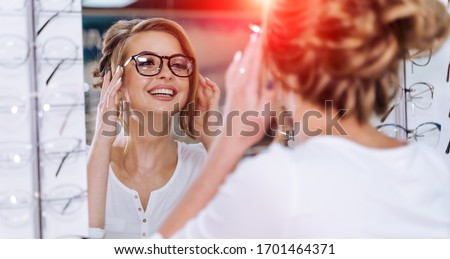 Young girl buys glasses. Optics. Emotions. Optical store Royalty-Free Stock Photo #1701464371