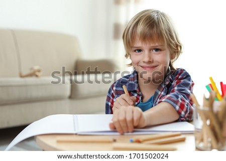 Little boy drawing at table indoors. Creative hobby