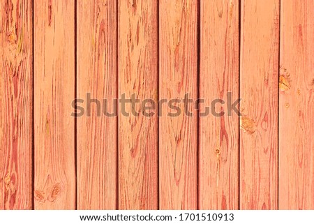Old plank wood coral background. Peeling faded red or orange paint on old boards. Copying space