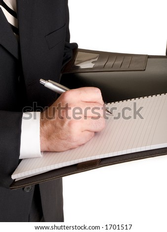 Stock photo of a well dressed businessman taking notes in a notebook.