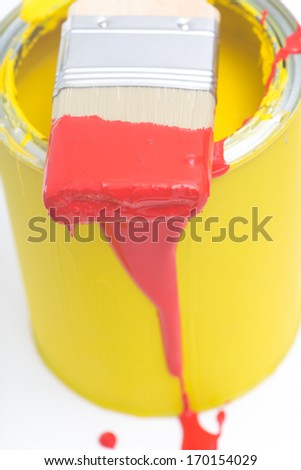 Yellow paint can with red brush