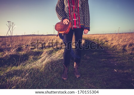 Young woman with handbag standing on nature trail