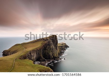 Neist Point and the lighthouse on Isle of Skye at sunset with beautiful colourful clouds in background - Scotland, UK
