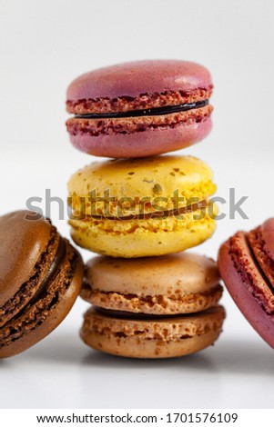 Stack of delicious traditional french macaroons. Colorful sweet dessert for real gourmands. Lemon, chocolate, caramel, raspberry flavors. White background, copy space, close up, macro
