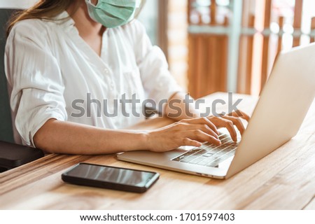 Woman work from home wearing mask protection wait for epidemic situation to improve soon at home. Coronavirus, covid-19, Work from home (WFH), Social distancing, Quarantine, Prevent infection concept. Royalty-Free Stock Photo #1701597403