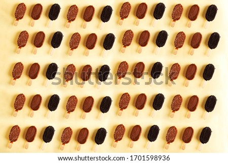
ice cream on a stick in chocolate pattern on a yellow background