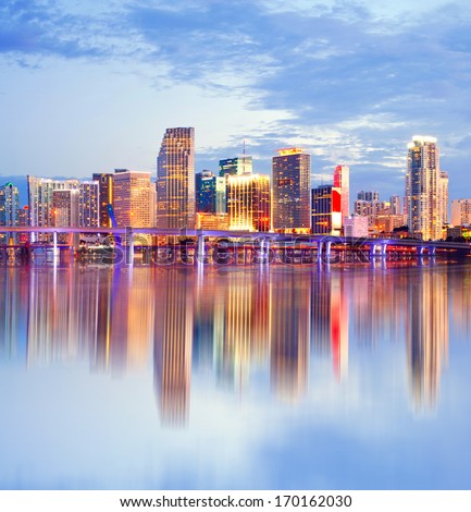 City of Miami Florida, night skyline. Cityscape of residential and business buildings illuminated at sunset with reflection