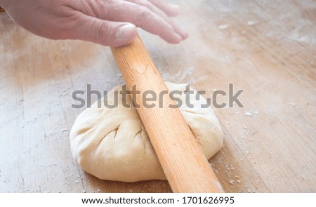 Woman rolling dough, close-up photo

A