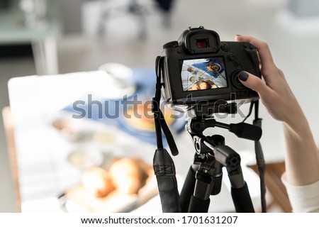 Photographer taking pictures of food and drinks. Female ready to taking photos on camera for food styling, carema on tripod