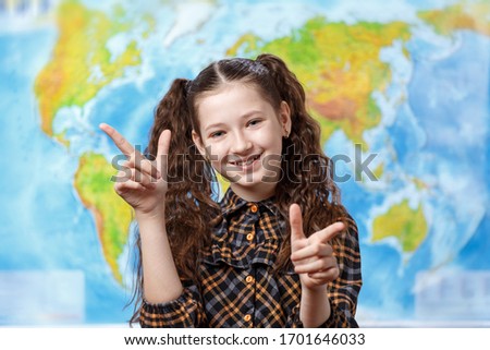 Beautiful teen girl on a background of the world map shows super