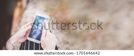 Woman worship with smartphone at home. Progress Bar Loading with the text: Jesus on smartphone screen. Church online concept. Royalty-Free Stock Photo #1701646642