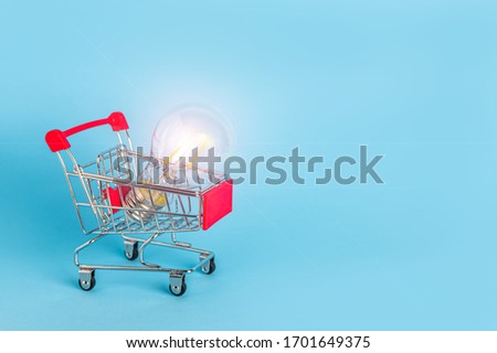 light bulb in a shopping trolley on a blue background