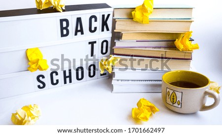 lightbox with BACK TO SCHOOL text and books on white background, Stack of old book education concept background, many books piles with copy space for text crumpled yellow paper