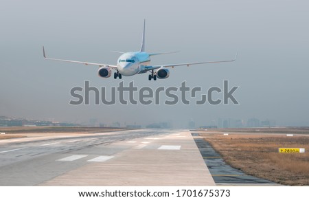 Passenger airplane landing to airport Royalty-Free Stock Photo #1701675373