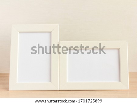 two empty photo frames on a table or shelf with a copy of the space.