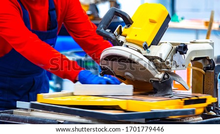 The Builder cuts the concrete block with a diamond disc. Circular saw blades for concrete. Circular saw for stone. A man cuts a stone with a circular saw. Building tool. Work with stone and tiles.