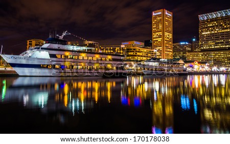 Buildings and boats reflecting in the Inner Harbor at night, Baltimore, Maryland.