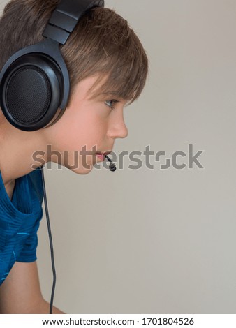 Concentrated child playing a console with a headset on