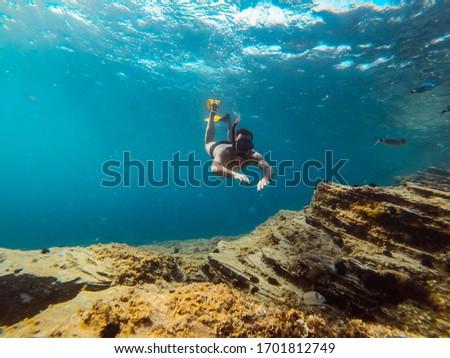 Underwater photo of men diver snorkeling in the sea water