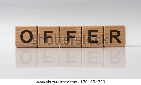 OFFER word concept written on wooden cubes lying on white glossy background