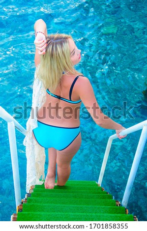 Girl in a swimsuit on the stairs to the sea